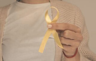 Kobieta trzymająca żółtą wstążkę – symbol świadomości endometriozy