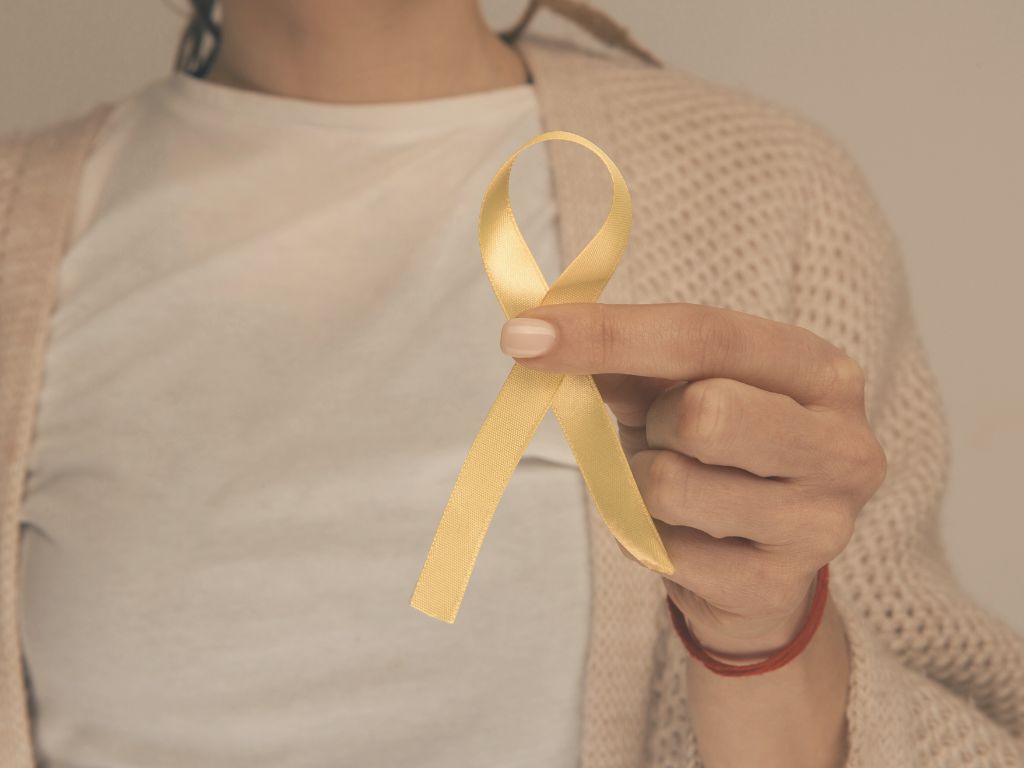 Kobieta trzymająca żółtą wstążkę – symbol świadomości endometriozy