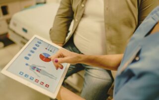 Lekarz analizuje wyniki badań hormonalnych u mężczyzny z nadwagą podczas konsultacji dotyczącej płodności.