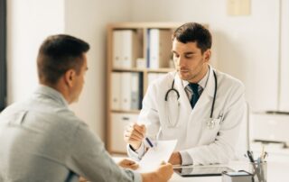 Lekarz konsultujący mężczyznę w gabinecie podczas diagnostyki niepłodności męskiej.